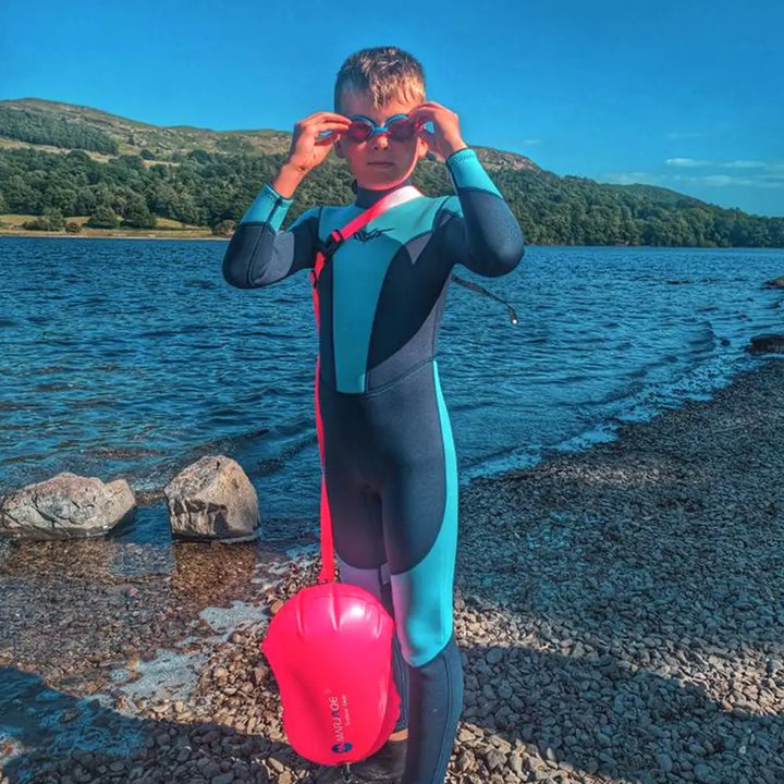 boys wetsuit, color navy and blue stand beside river